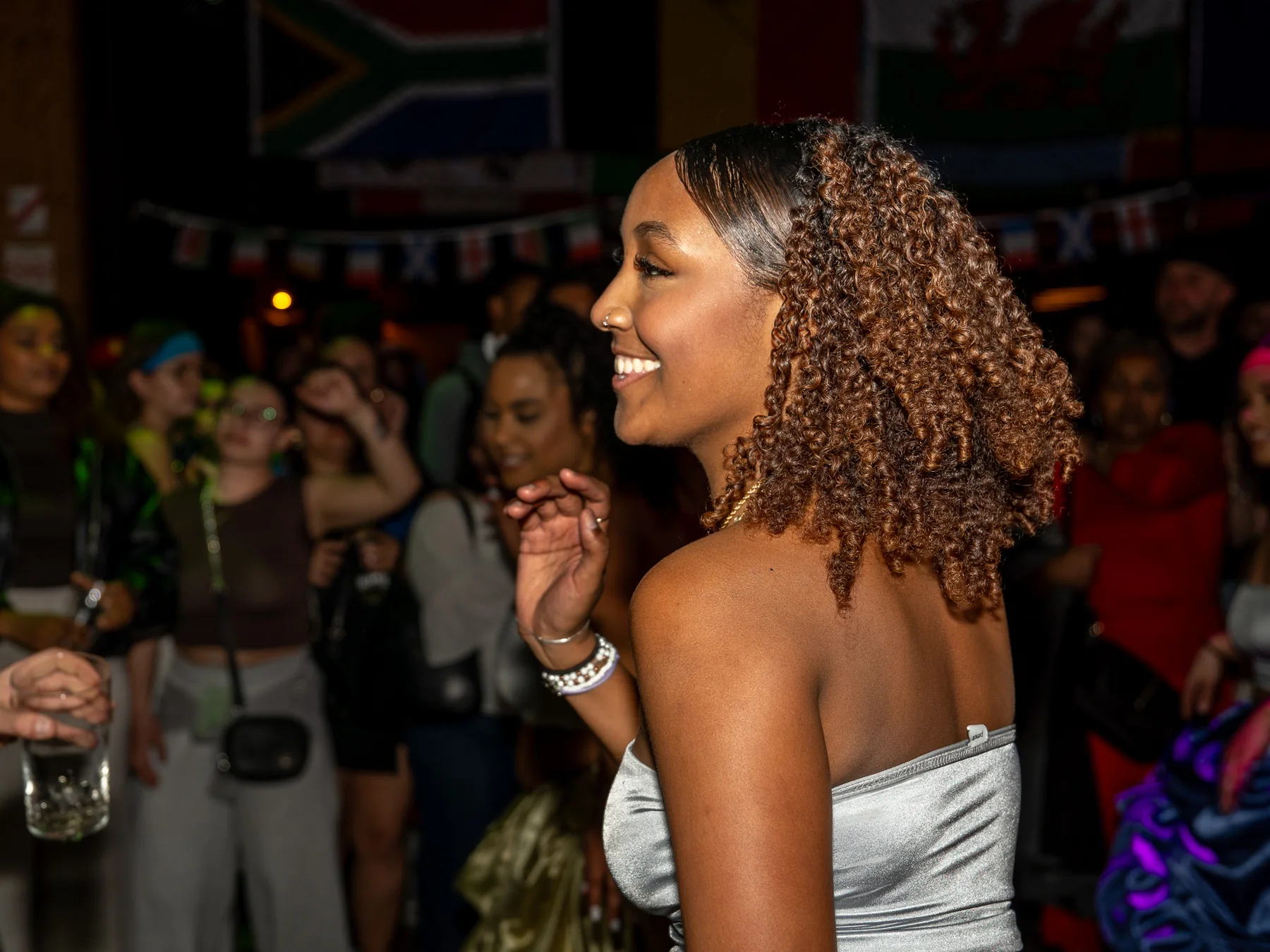Danseuse souriante en tenue argentée lors d’un événement culturel